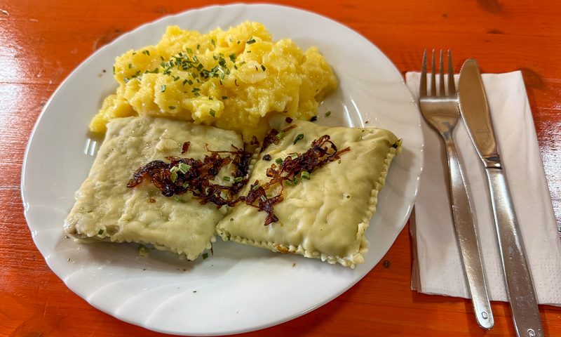 Ein Teller mit zwei Maultaschen und Kartoffelsalat
